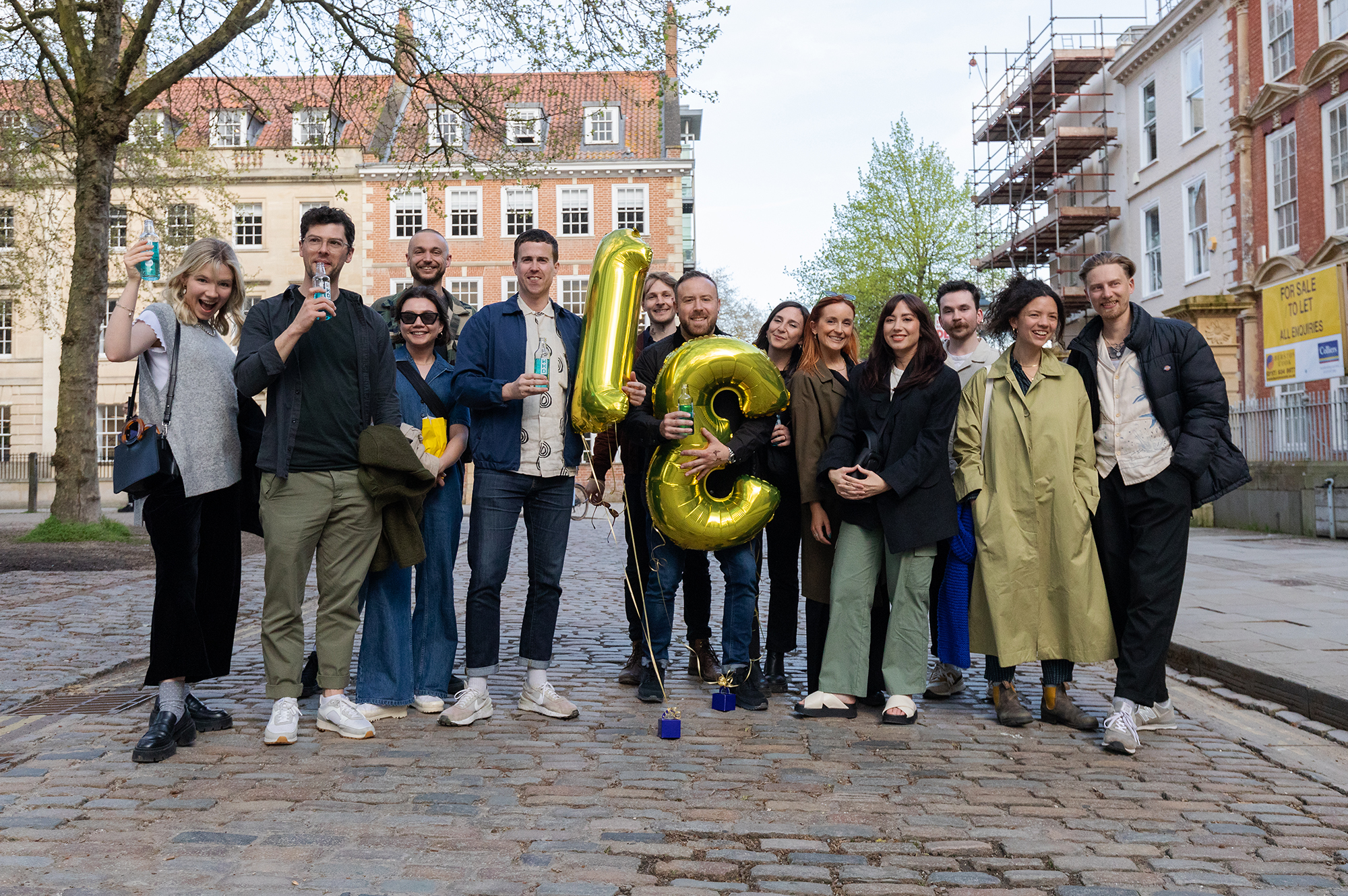 Fiasco Design turns 13! Photo shows Fiasco team holding balloons that spell out 13 on their birthday celebrations