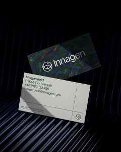 Mock up of Innagen business card. The front uses the Innagen logo against dark brand colours, whilst the front shows name, job title and key information in Innagen brand font.