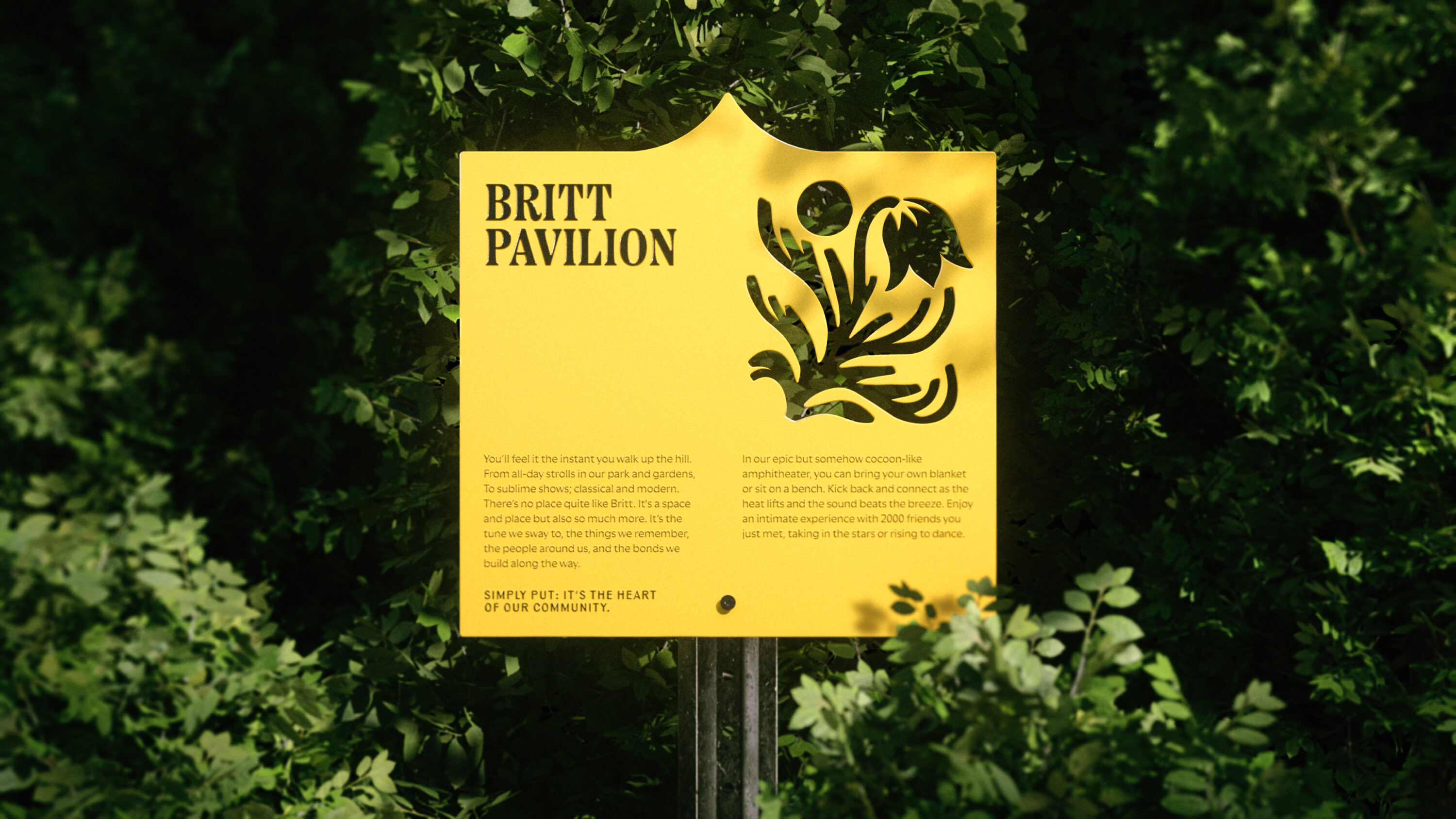 Image shows the Britt wayfinding sign in situ. The sign is yellow, with 'Britt Pavilion' written along with smaller text underneath, and the fauna logo on the right. Green shrubbery is behind the sign.